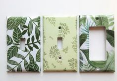 three light switch covers with green leaves on them