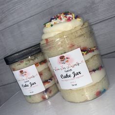 two jars filled with cake mix sitting on top of a table