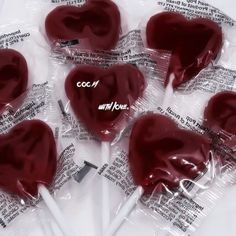 six heart shaped lollipops wrapped in plastic wrappers