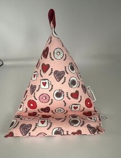 a pink triangle with hearts and donuts on it