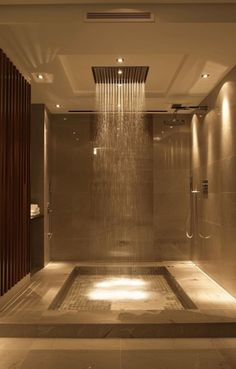 a shower head in the middle of a tiled floored area with lights on either side