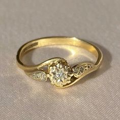 a yellow gold ring with two diamonds on it