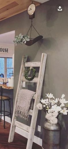 a ladder is leaning against the wall next to a table and chairs in a room