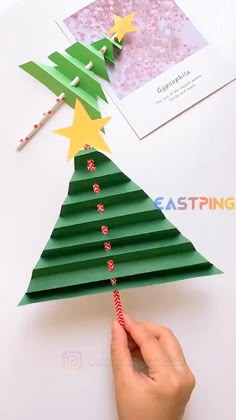 someone is making a christmas tree out of construction paper and straws on the top