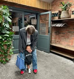 a man standing next to a little boy in front of a store