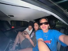 three women sitting in the back of a car