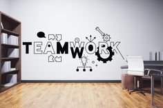 a wall with the word teamwork written on it in black and white, next to a bookcase