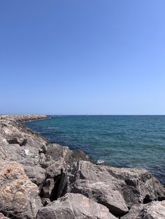 a person standing on rocks near the ocean