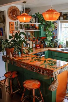 an island in the middle of a kitchen with two stools and plants on it