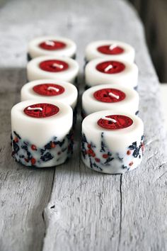 six white dices with red and black designs on them sitting on top of a wooden table