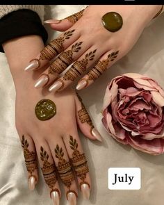 two hands with henna tattoos on them and a flower in the middle, next to it