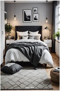 a bedroom with grey walls and white bedding, two framed pictures on the wall