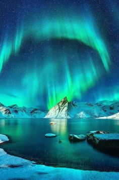 an aurora bore is seen over the mountains and water