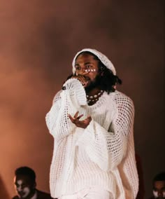 a man standing on top of a stage with his hands in his pockets and mouth open