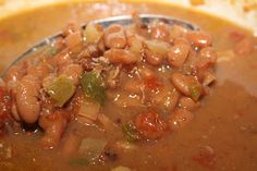 a spoon full of soup with beans and onions