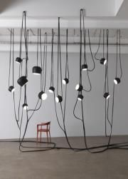 a chair sitting in front of a bunch of lights hanging from the side of a wall