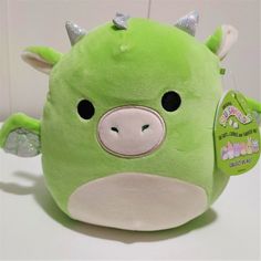 a green stuffed animal with horns on it's head