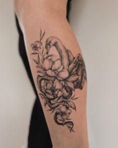 a woman's arm with flowers and an angel tattoo on the left side of her arm