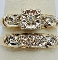 two gold wedding rings sitting on top of each other