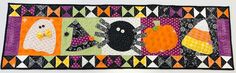 a quilted wall hanging with halloween decorations on it