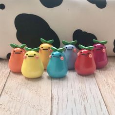 five little toy animals are lined up in front of a cow