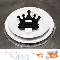 a white plate topped with a black crown