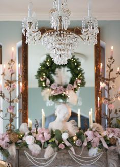 a fireplace decorated for christmas with pink flowers and greenery