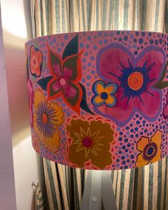 a colorful lamp shade with flowers painted on it