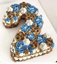 a cake shaped like the number six with blue and white frosting on it's face