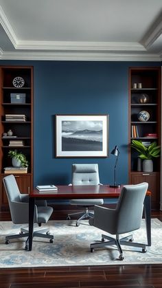 an office with blue walls and wooden shelves on either side, two chairs are facing the desk