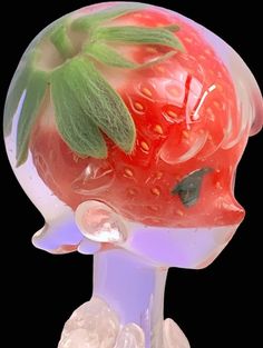 a glass figurine with a strawberry on it's head