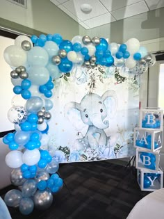 an elephant themed balloon arch with blue and silver balloons in the shape of baby's first year