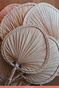 three wicker umbrellas sitting on top of a wooden table next to each other