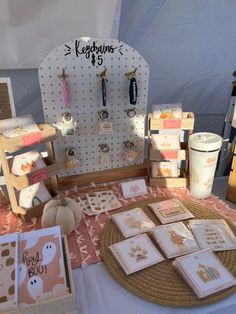 the table is set up with cards and other items for sale at this outdoor market