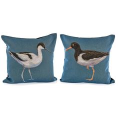 two blue pillows with birds on them, one is black and the other is white