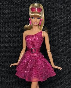 a barbie doll wearing a pink dress and red shoes