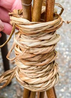 a hand holding a bundle of bamboo sticks in it's wrap around holder on a table