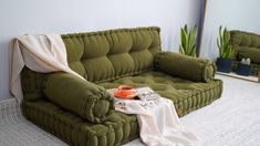 a green couch sitting on top of a white rug