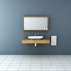 a white sink sitting under a mirror on top of a wooden counter next to a towel dispenser