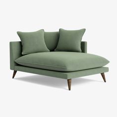 a green couch with two pillows on the back and one arm folded up to show it's shape