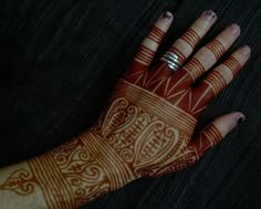 a woman's hand with henna tattoos on it