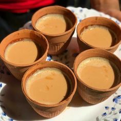 four cups filled with liquid sitting on top of a plate