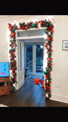 christmas decorations on the wall in front of a door with a tv and large window