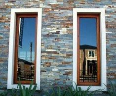 two windows are shown in front of a brick building