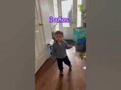 a little boy standing in front of a door with the words 2 famos on it