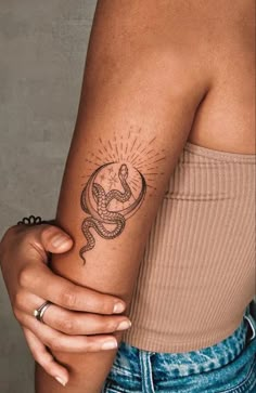 a woman with a snake tattoo on her arm