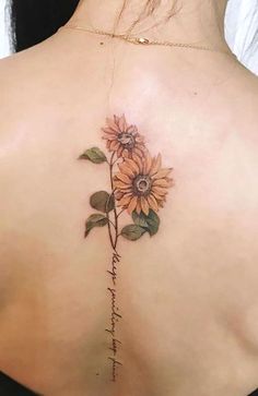 the back of a woman's shoulder with sunflowers on it