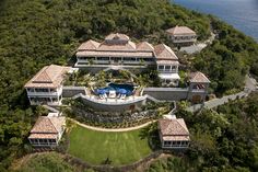 an aerial view of a large house in the middle of some trees and grass with a pool