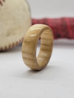 a wooden ring sitting on top of a table next to a baseball bat and ball