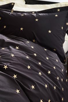 black and white bedding with gold stars on it, along with two pillow cases